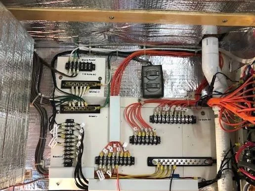 Marine DC distribution panel with labeled wiring, terminal blocks, busbar, and circuit protection