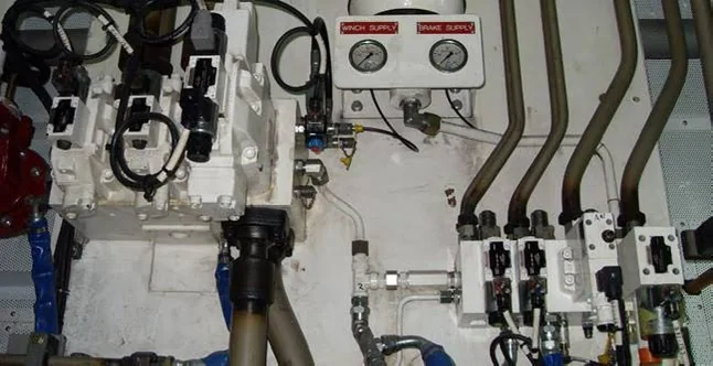 Marine hydraulic control manifold with valves, pressure gauges, and routed piping