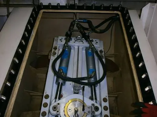Dual-cylinder marine hydraulic actuator assembly with connected hoses inside a compartment