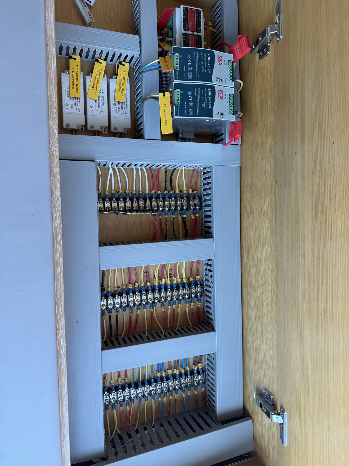 Open marine electrical enclosure with power supplies, terminal blocks and wire routing.