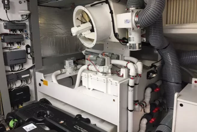Engine-room fan blower in the upper middle with a VacuFlush toilet system in the lower middle and surrounding piping.