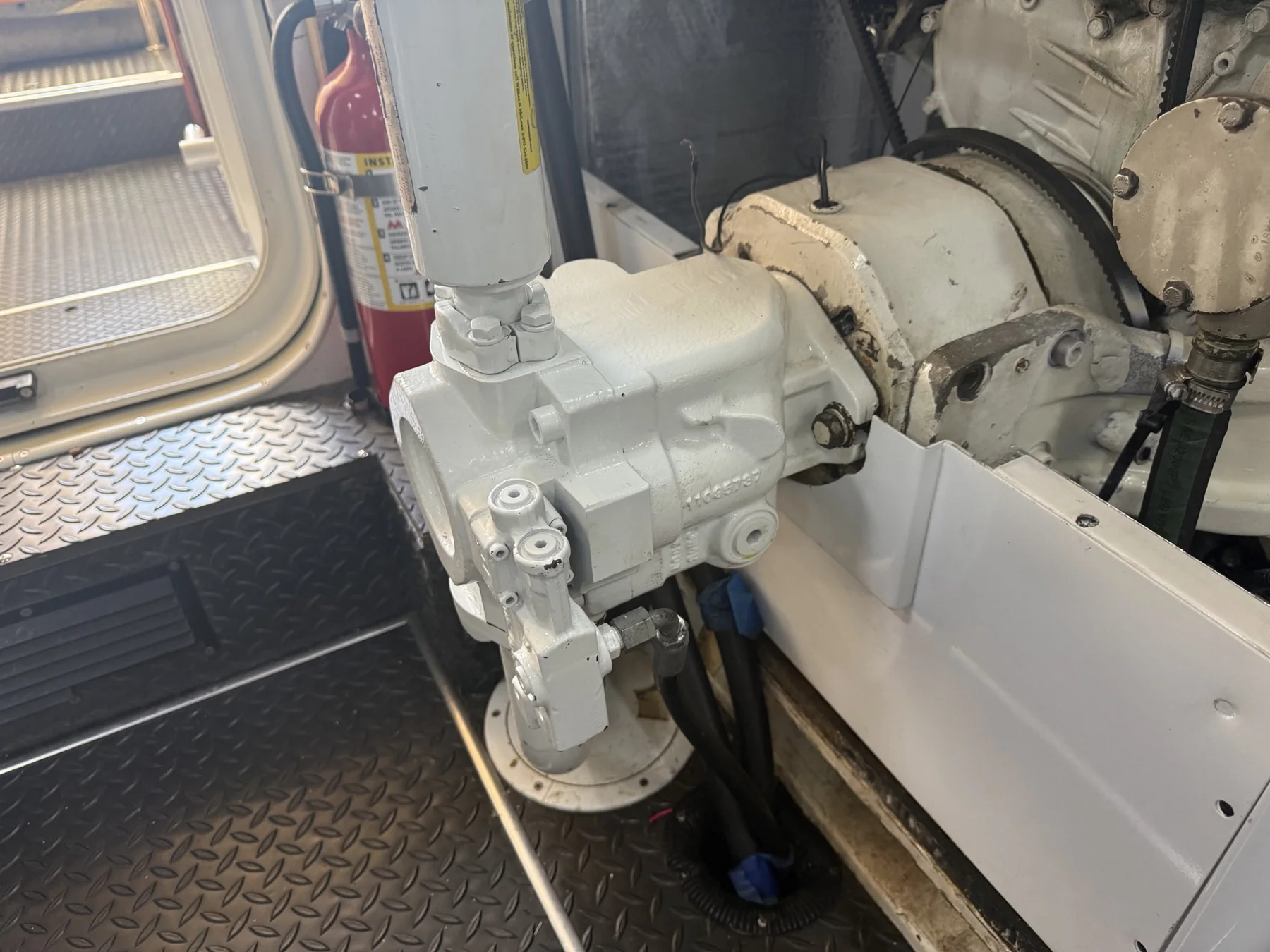 Engine-driven marine hydraulic pump mounted in a machinery space.