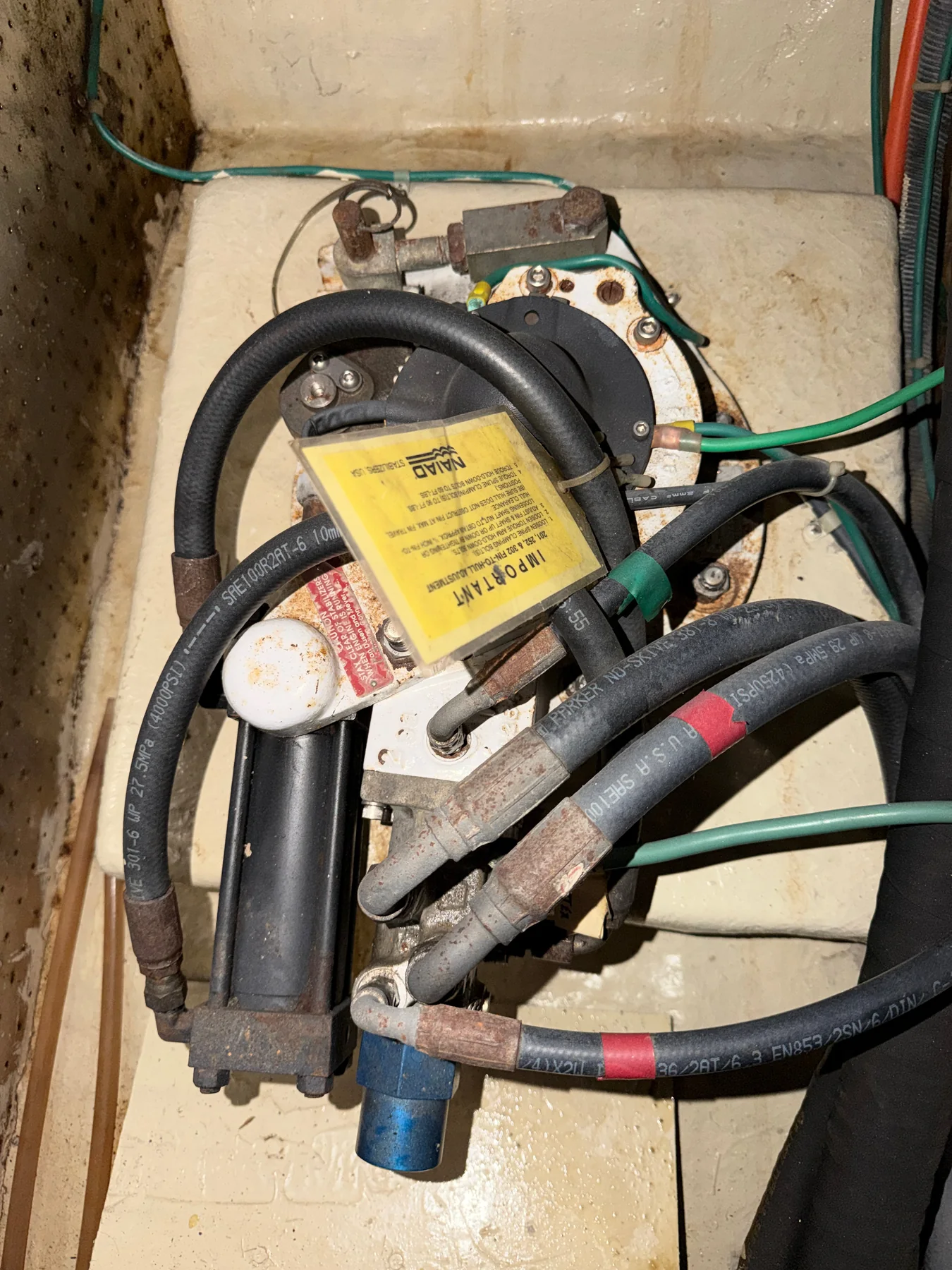 Installed Naiad stabilizer actuator with hydraulic cylinder, hoses, fittings, and service label