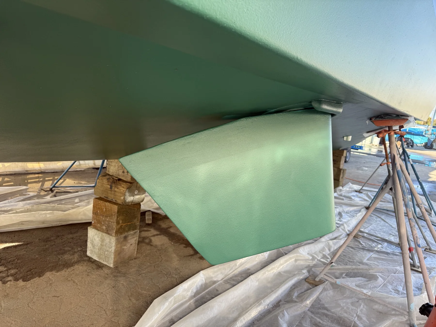 Marine stabilizer fin installed on a vessel hull in a boatyard