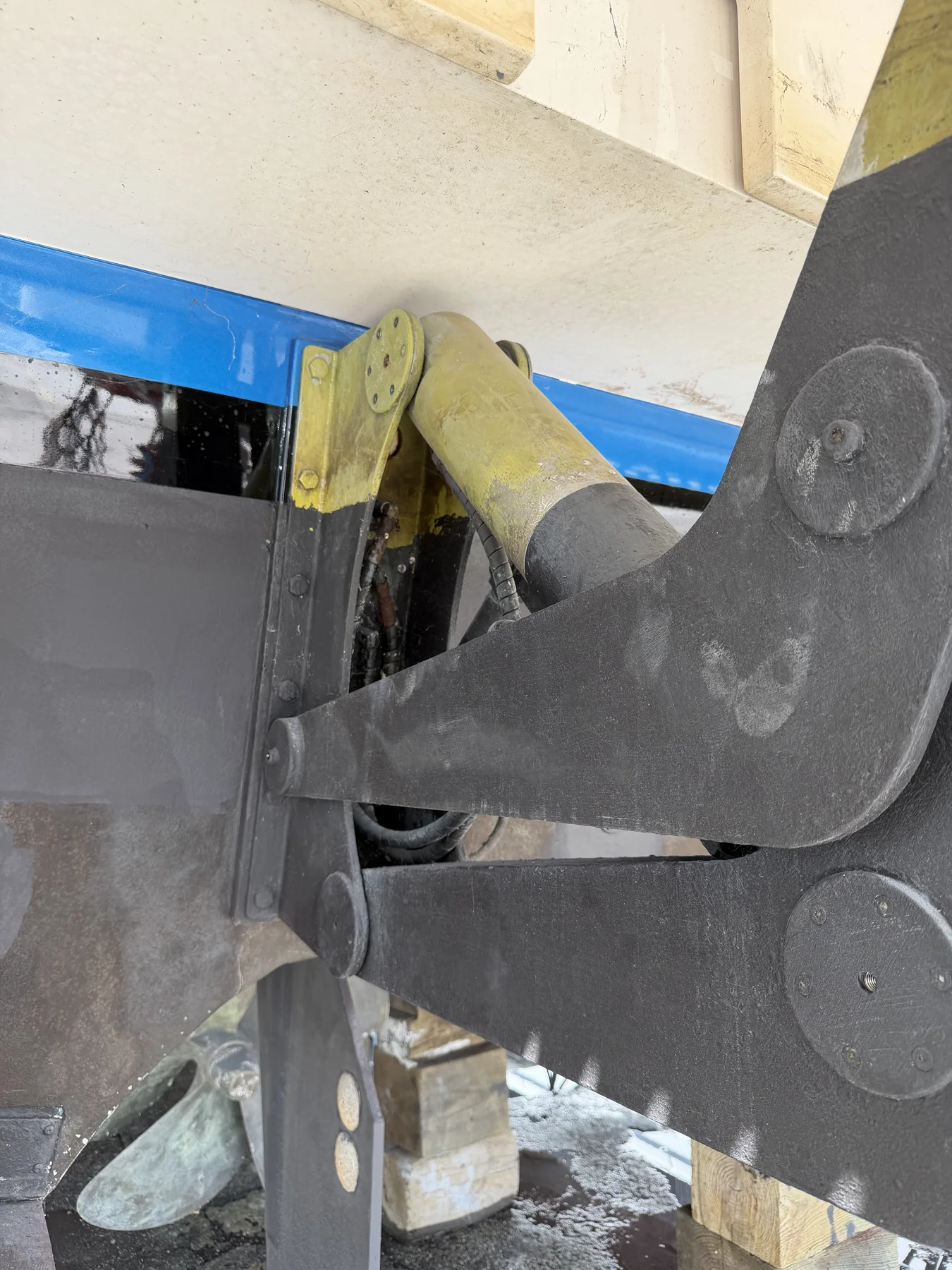 Marine swim-platform hydraulic cylinder and hinged support beneath a vessel.