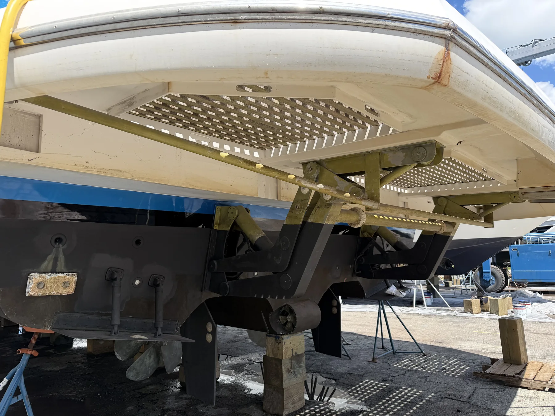 Underside of a marine swim platform with hydraulic lifting linkage.
