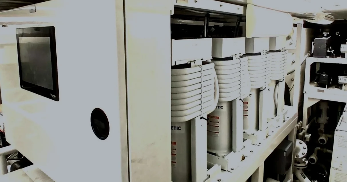 Marine chiller modules beside a control cabinet and chilled-water piping