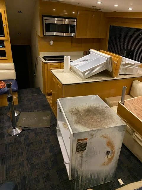 Removed refrigerator and freezer unit inside a yacht interior during replacement work