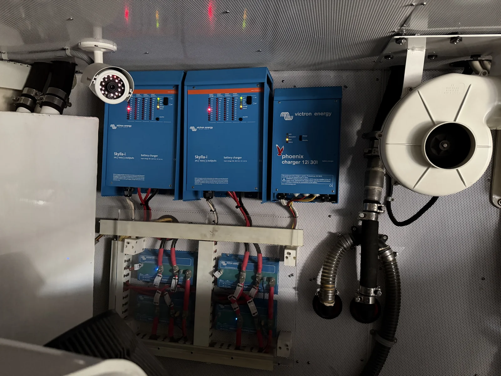Victron Energy battery chargers mounted above connected batteries.